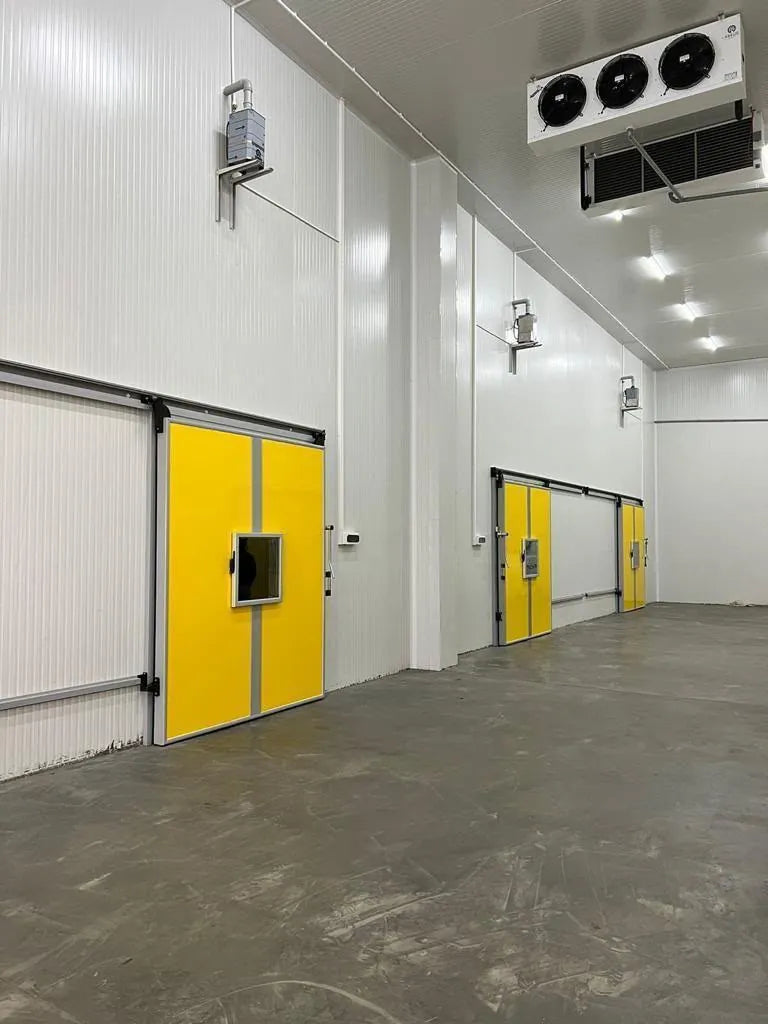 Tall cold store with yellow sliding doors and ceiling-mounted evaporator fans